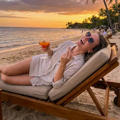 A woman on the beach enjoying a sunset